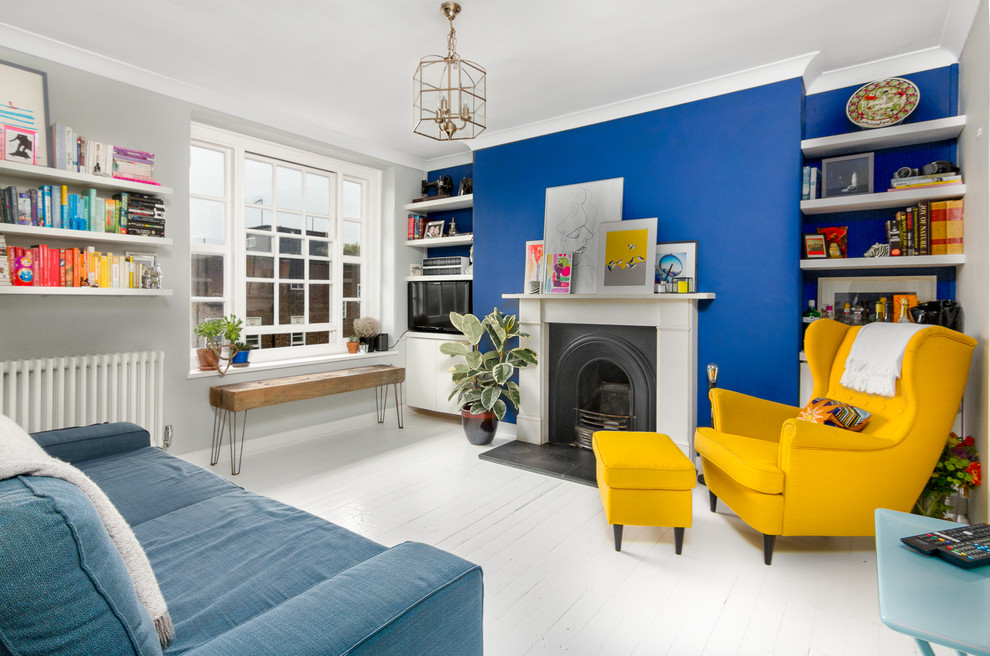 Свежая идея для дизайна: изолированная гостиная комната в современном стиле с синими стенами, деревянным полом, стандартным камином, фасадом камина из дерева, белым полом и синим диваном - отличное фото интерьера