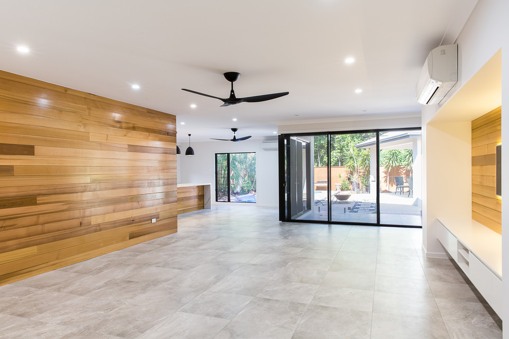 Ejemplo de salón abierto contemporáneo con suelo de baldosas de cerámica, pared multimedia, suelo gris y paredes grises