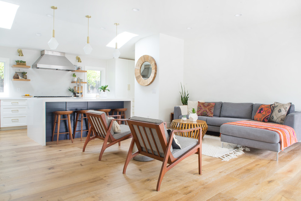 Diseño de salón abierto vintage de tamaño medio con paredes blancas y suelo de madera clara