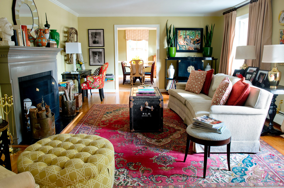 Foto på ett mellanstort eklektiskt separat vardagsrum, med ett finrum, gula väggar, mellanmörkt trägolv, en standard öppen spis och en spiselkrans i tegelsten