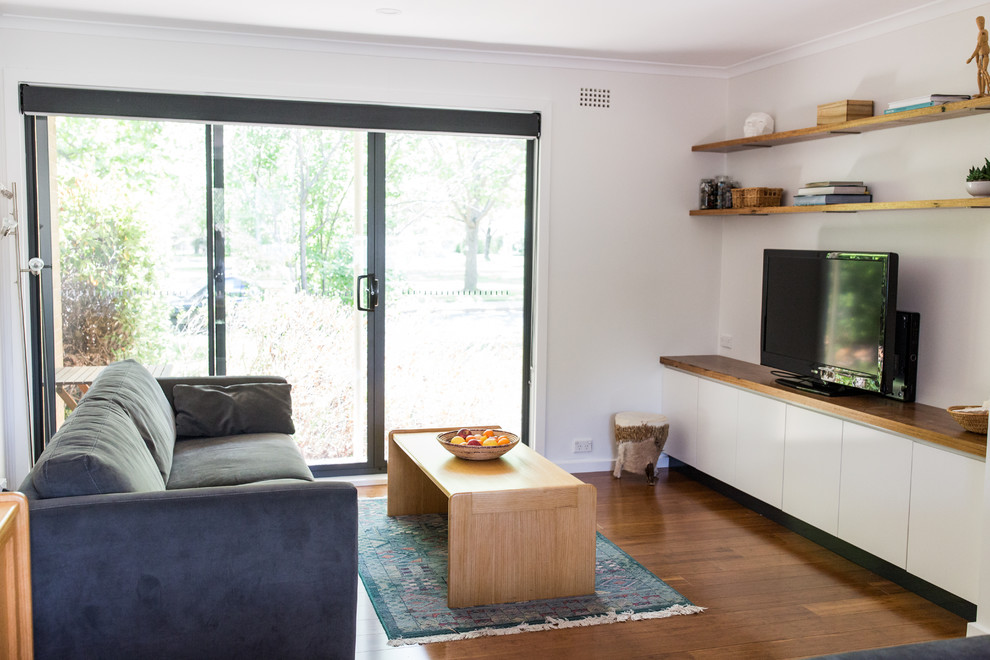 Идея дизайна: маленькая открытая гостиная комната в стиле модернизм с полом из бамбука, отдельно стоящим телевизором и коричневым полом для на участке и в саду