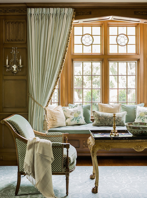 Бирюзовые шторы на окне и ткань на кресле в сочетании с деревянными панелями
