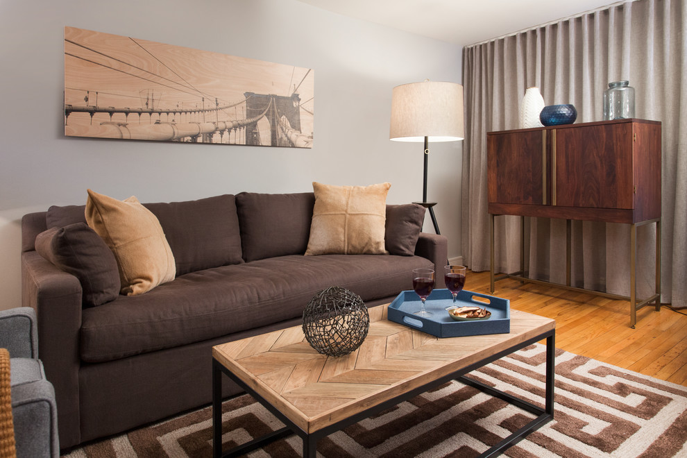 Modelo de salón para visitas cerrado rústico de tamaño medio sin chimenea con paredes grises, suelo de madera clara y televisor independiente