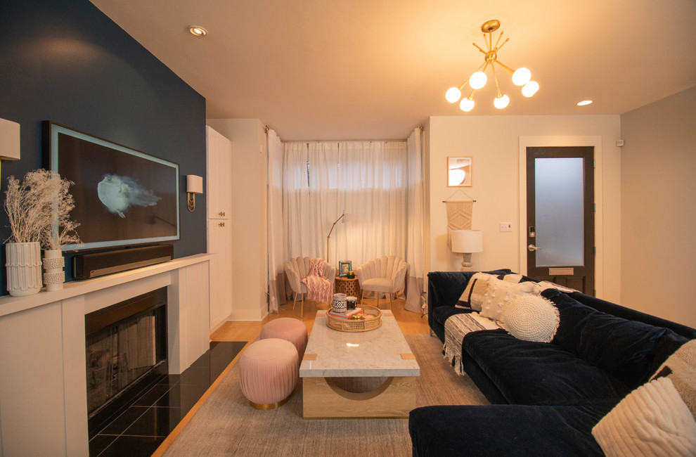 Пример оригинального дизайна: большая открытая гостиная комната в современном стиле с синими стенами, светлым паркетным полом, стандартным камином, фасадом камина из дерева, телевизором на стене и желтым полом