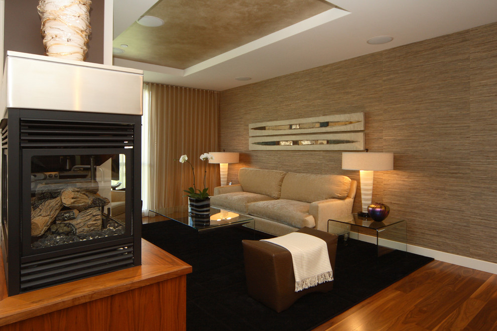 Modelo de salón abierto tradicional renovado de tamaño medio con paredes beige, suelo de madera en tonos medios, chimenea de esquina, marco de chimenea de madera y pared multimedia