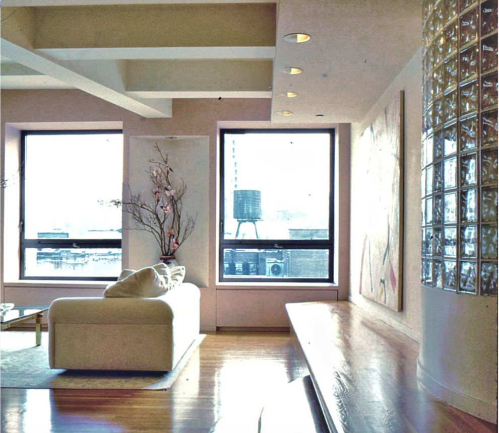 Inspiration pour un grand salon mansardé ou avec mezzanine minimaliste avec un mur rose, parquet clair et un sol marron.