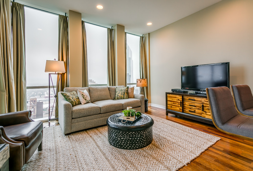 Immagine di un soggiorno minimal di medie dimensioni e aperto con sala formale, pareti beige, pavimento in legno massello medio e TV autoportante