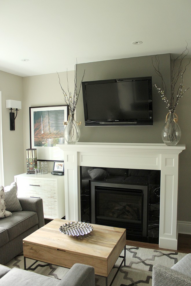 Small classic open plan living room in Toronto with grey walls, medium hardwood flooring, a standard fireplace, a stone fireplace surround and a wall mounted tv.