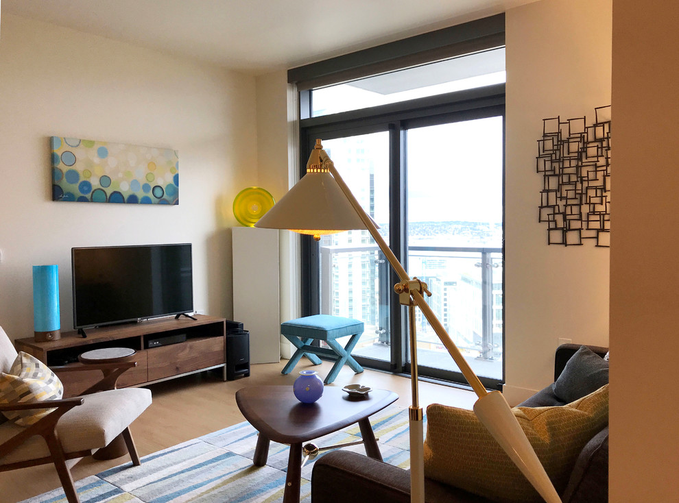 Immagine di un piccolo soggiorno minimalista aperto con angolo bar, pareti bianche, pavimento in laminato, TV autoportante e pavimento beige