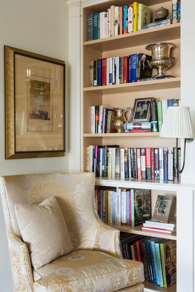 Cette photo montre un salon chic de taille moyenne avec une bibliothèque ou un coin lecture, un mur beige, aucune cheminée et aucun téléviseur.