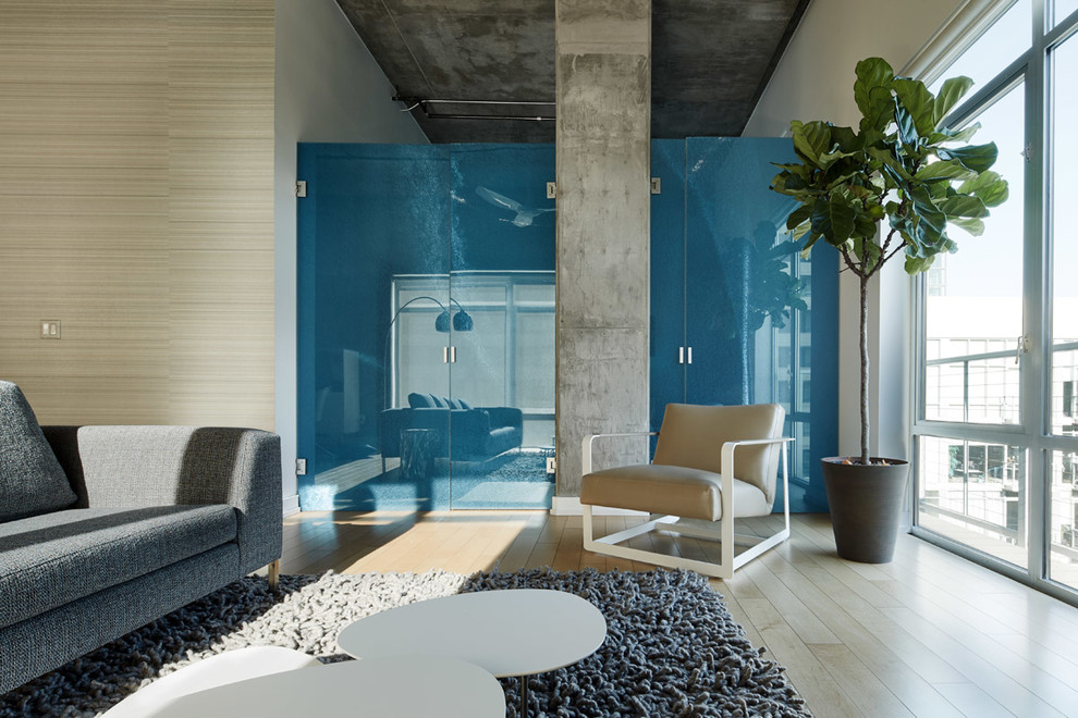 Esempio di un soggiorno minimalista di medie dimensioni e stile loft con pareti bianche, parquet chiaro e TV a parete