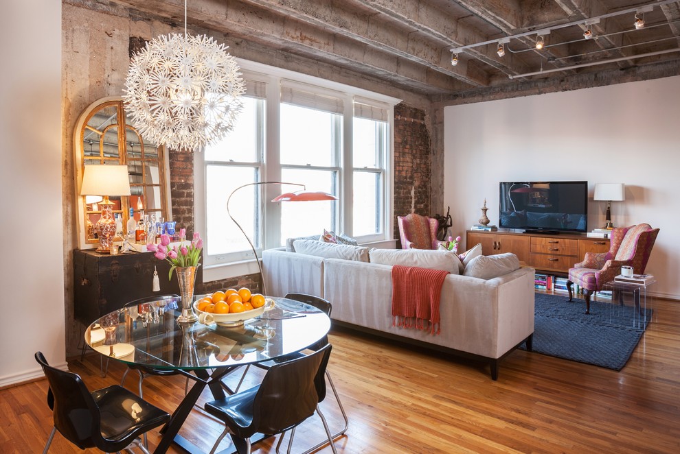 Offenes Modernes Wohnzimmer mit braunem Holzboden und freistehendem TV in Houston