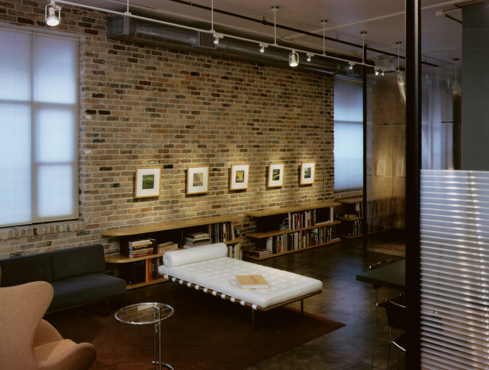 Industriell inredning av ett vardagsrum, med ett bibliotek och betonggolv