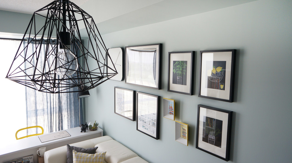 На фото: маленькая изолированная гостиная комната в стиле модернизм с синими стенами, темным паркетным полом и отдельно стоящим телевизором для на участке и в саду