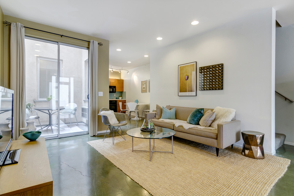 Modernes Wohnzimmer mit freistehendem TV und grünem Boden in San Diego