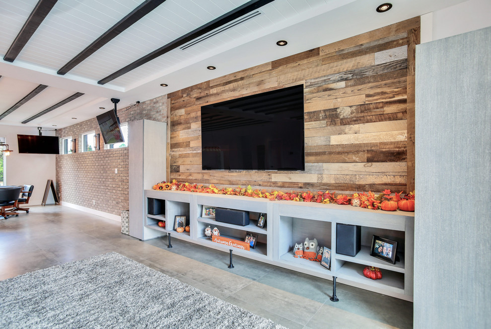 На фото: парадная, открытая гостиная комната среднего размера в стиле лофт с разноцветными стенами, телевизором на стене и серым полом с