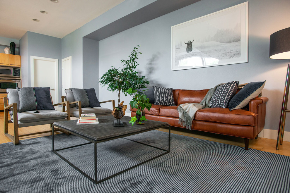 Mittelgroßes, Repräsentatives, Fernseherloses Modernes Wohnzimmer ohne Kamin, im Loft-Stil mit blauer Wandfarbe und braunem Holzboden in Denver