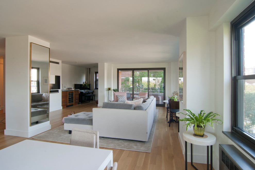Exempel på ett mellanstort modernt allrum med öppen planlösning, med en hemmabar, vita väggar, ljust trägolv, en väggmonterad TV och beiget golv