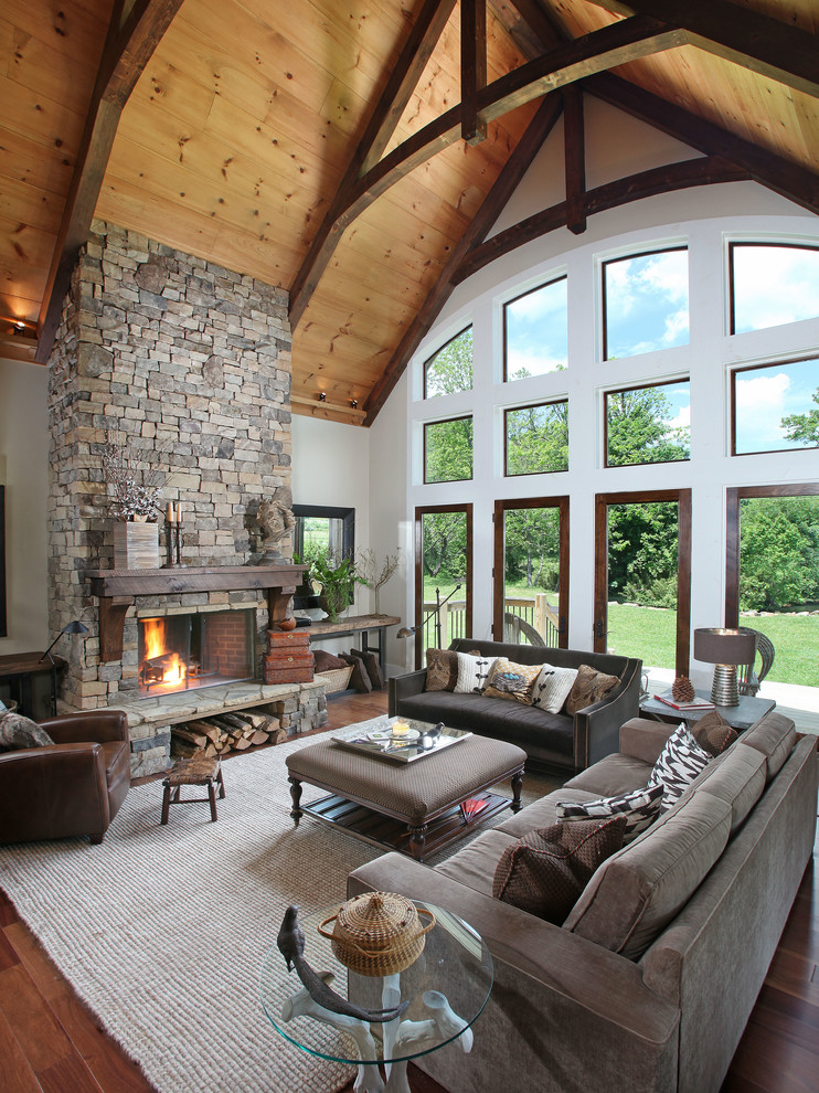 Exemple d'un très grand salon tendance ouvert avec une cheminée standard, un manteau de cheminée en pierre et éclairage.