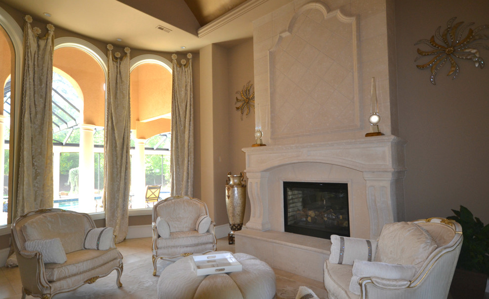 Réalisation d'un très grand salon méditerranéen fermé avec une salle de réception, un mur beige, un sol en travertin, une cheminée standard et un manteau de cheminée en pierre.