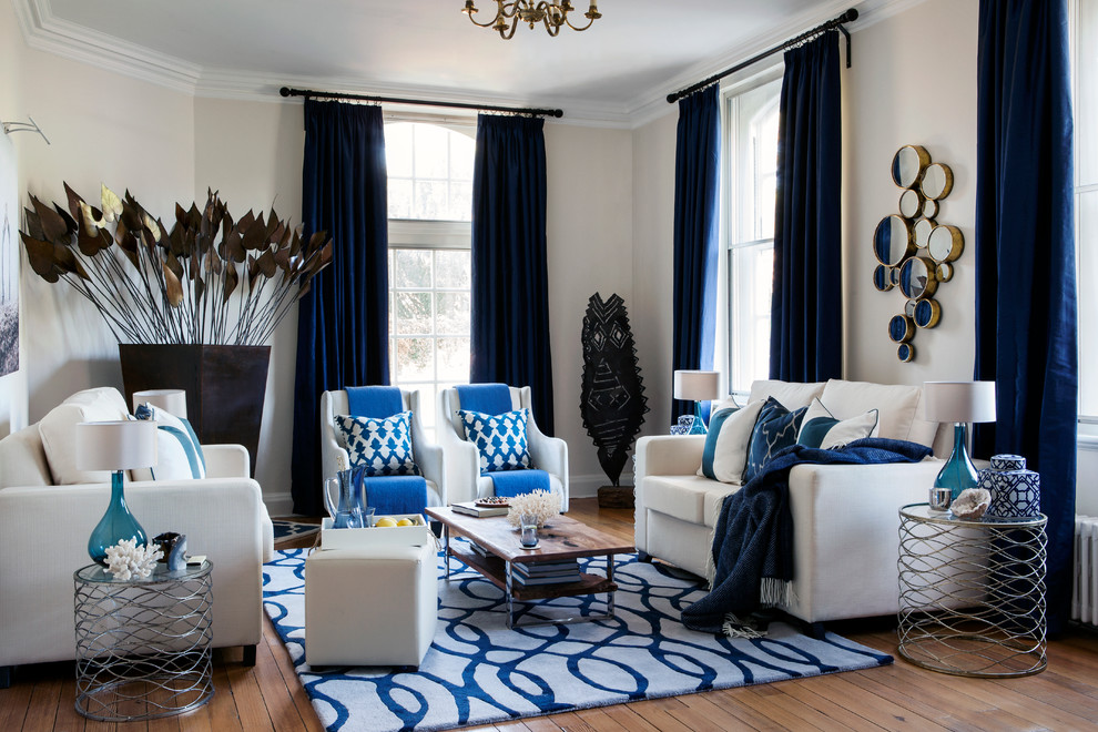 Идея дизайна: парадная гостиная комната в стиле неоклассика (современная классика) с бежевыми стенами, паркетным полом среднего тона и синими шторами