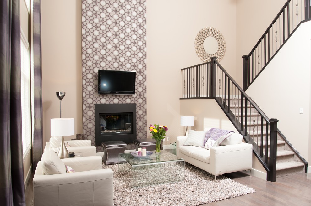Foto de salón para visitas abierto contemporáneo con paredes beige, suelo de madera clara, todas las chimeneas, marco de chimenea de metal y televisor colgado en la pared