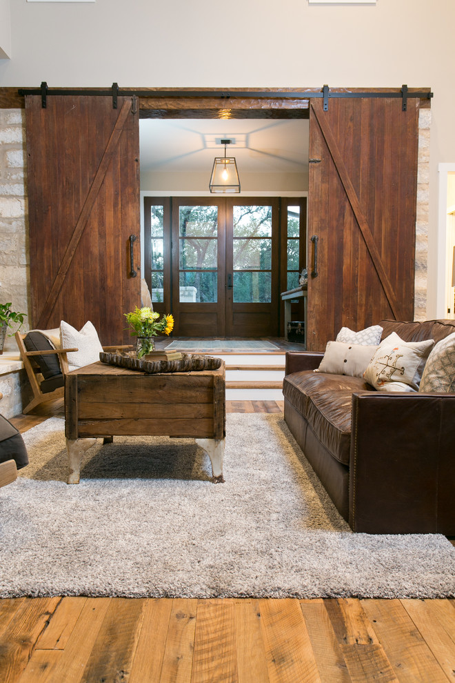 Cottage open concept medium tone wood floor living room photo in Austin with beige walls, a standard fireplace and a stone fireplace
