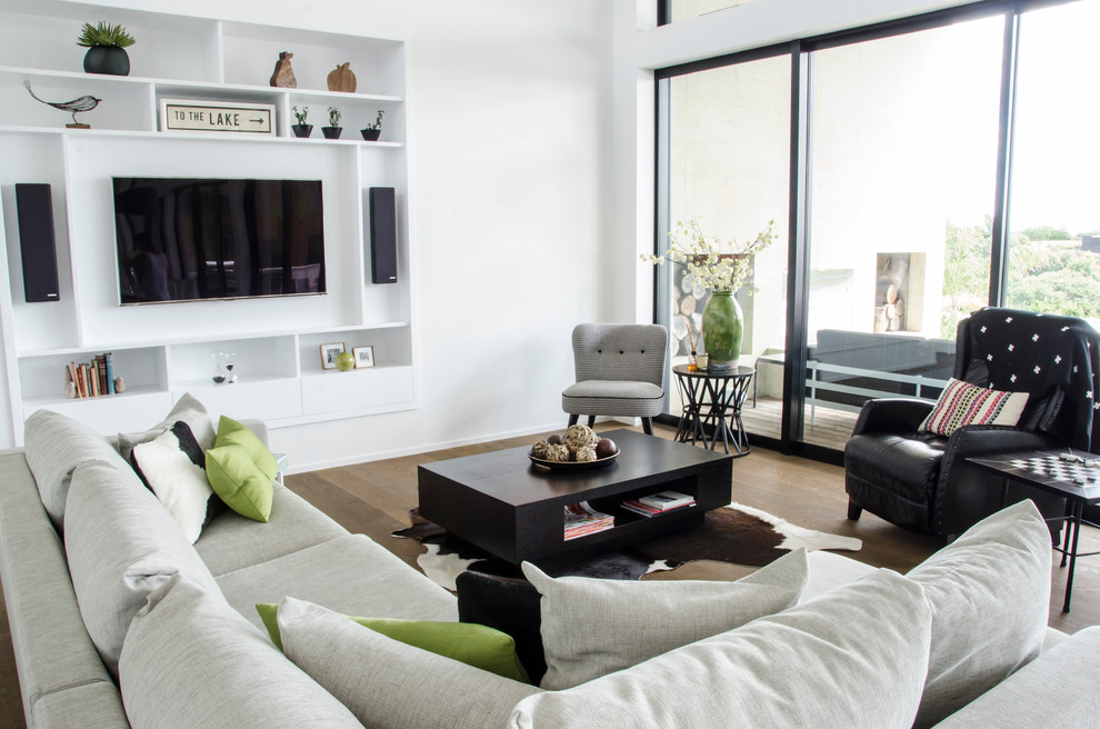 Repräsentatives, Abgetrenntes Modernes Wohnzimmer mit weißer Wandfarbe, hellem Holzboden und Multimediawand in Hamilton