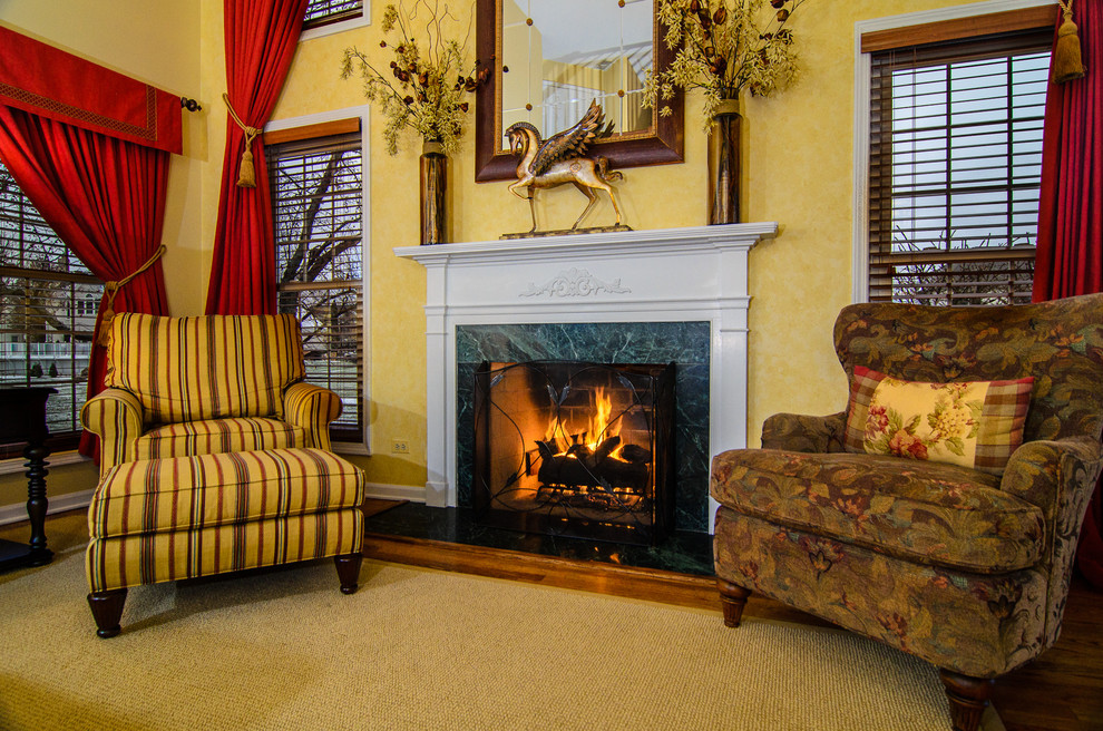 Large elegant formal and open concept medium tone wood floor living room photo in Chicago with yellow walls, a standard fireplace and a wood fireplace surround