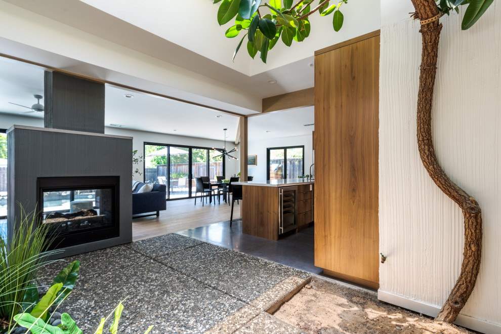 Inspiration for a mid-sized mid-century modern open concept light wood floor and brown floor living room remodel in Sacramento with white walls and a two-sided fireplace