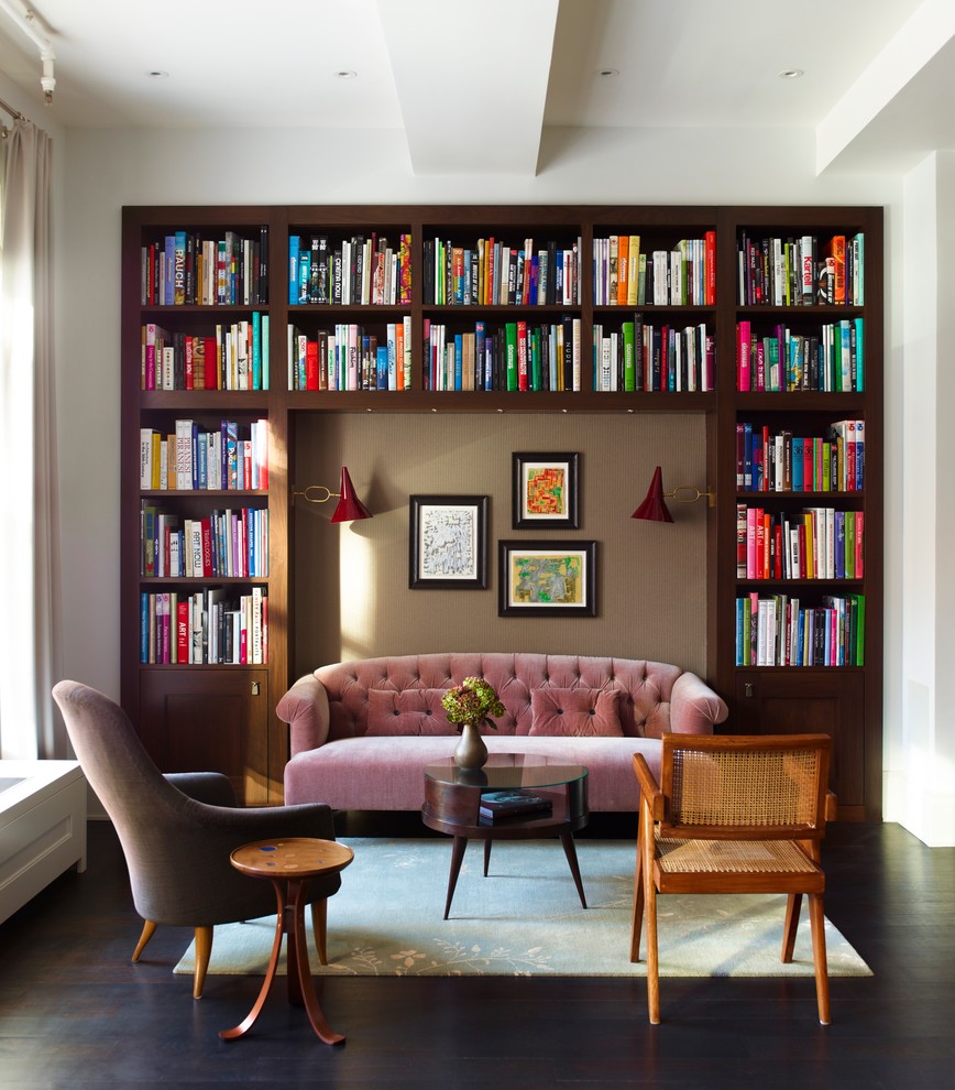 Cette photo montre un salon chic ouvert avec une bibliothèque ou un coin lecture, un mur blanc et parquet foncé.