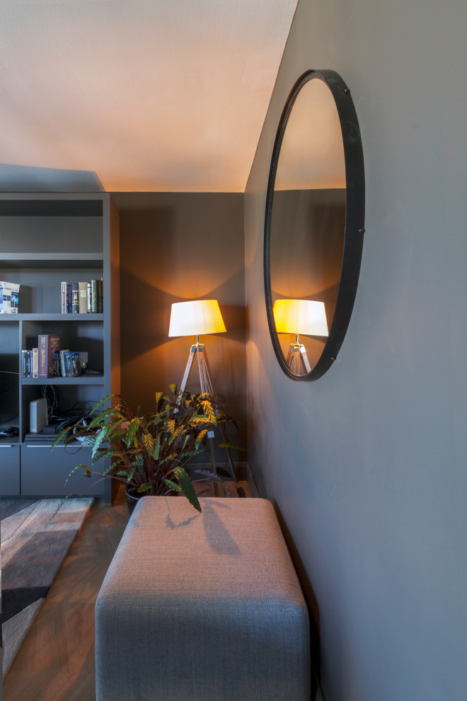 Пример оригинального дизайна: открытая гостиная комната среднего размера в современном стиле с черными стенами, темным паркетным полом, мультимедийным центром и коричневым полом