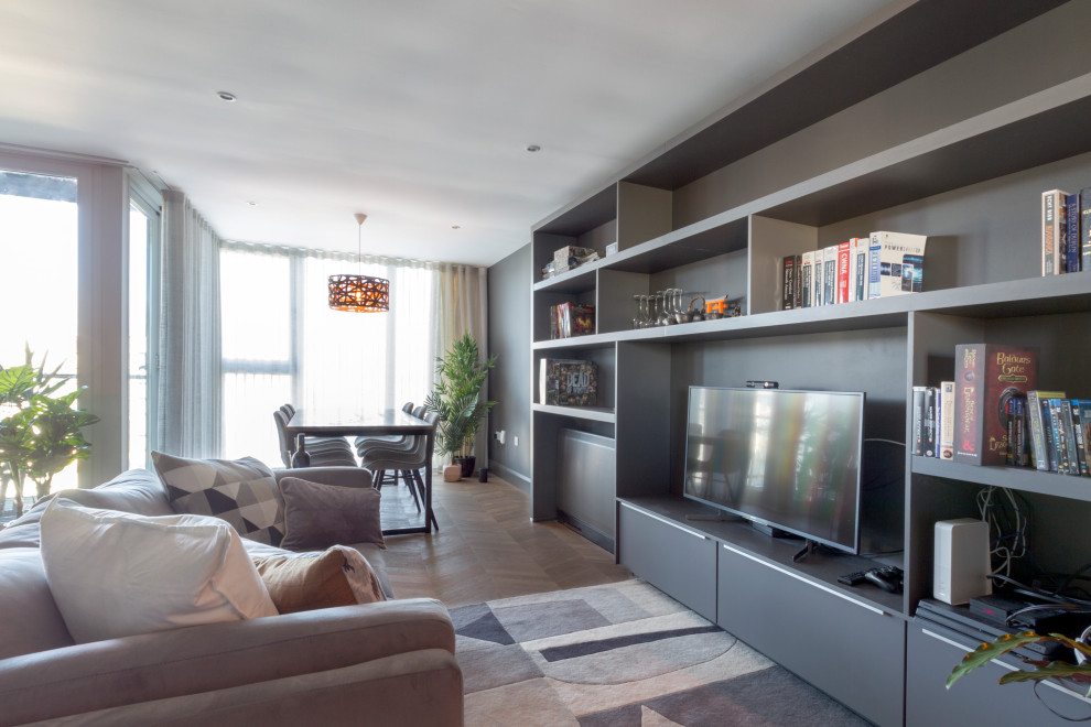Cette image montre un salon design de taille moyenne et ouvert avec un mur noir, parquet foncé, un téléviseur encastré et un sol marron.