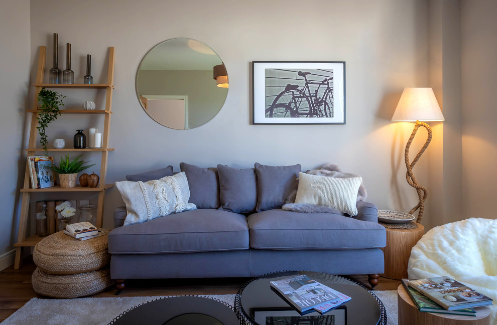 Foto di un soggiorno minimal di medie dimensioni e chiuso con libreria, pareti beige, parquet chiaro e pavimento marrone