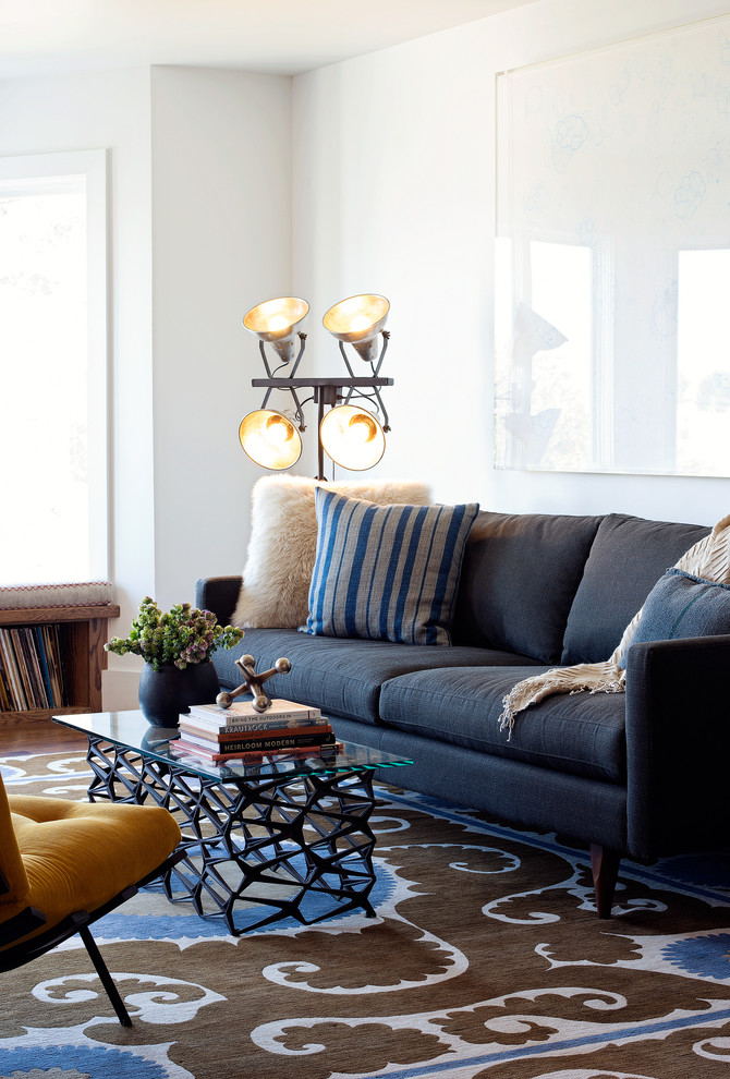 Стильный дизайн: гостиная комната в стиле лофт с белыми стенами и синим диваном - последний тренд