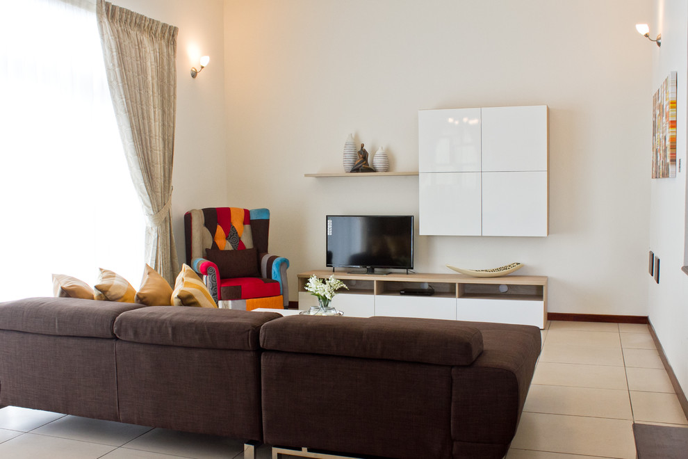 Kleines, Abgetrenntes Modernes Wohnzimmer mit beiger Wandfarbe, Porzellan-Bodenfliesen und freistehendem TV in Sonstige