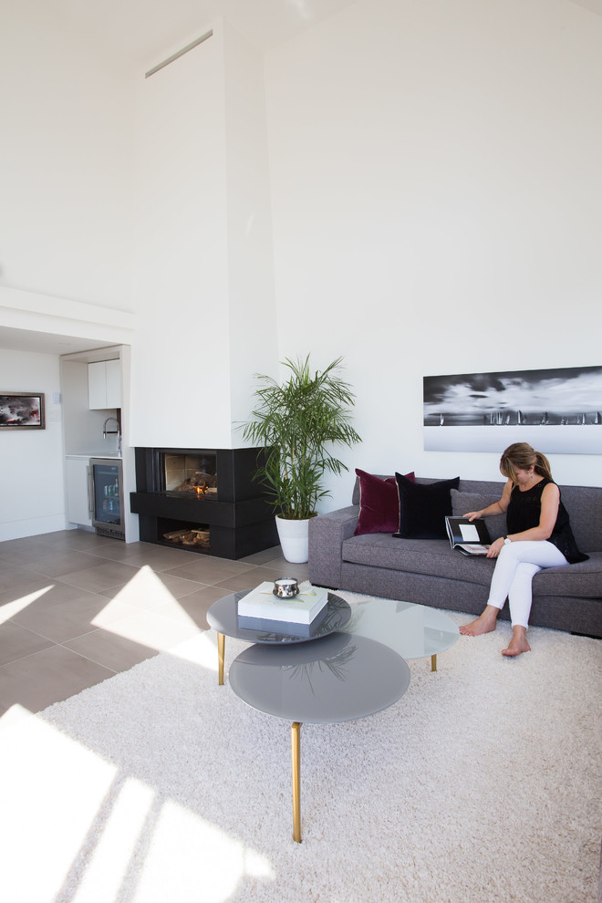 Großes, Repräsentatives, Fernseherloses, Offenes Modernes Wohnzimmer mit weißer Wandfarbe, Porzellan-Bodenfliesen, Kamin, Kaminumrandung aus Metall und beigem Boden in Vancouver