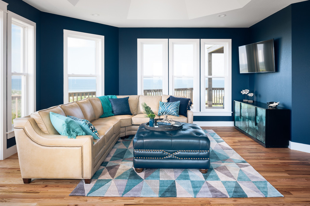 Mittelgroßes, Abgetrenntes Maritimes Wohnzimmer mit blauer Wandfarbe, braunem Holzboden, TV-Wand und braunem Boden in Sonstige
