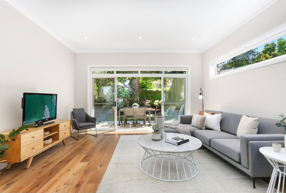 Foto di un soggiorno minimalista con pavimento in legno massello medio