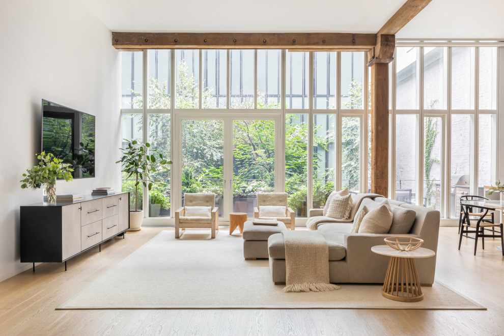 Immagine di un grande soggiorno contemporaneo stile loft con pareti bianche, parquet chiaro, nessun camino, TV autoportante e pavimento marrone