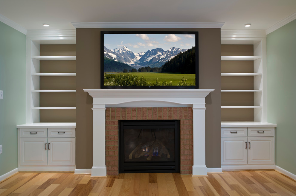 ワシントンD.C.にある中くらいなトラディショナルスタイルのおしゃれなLDK (茶色い壁、淡色無垢フローリング、標準型暖炉、レンガの暖炉まわり、壁掛け型テレビ) の写真