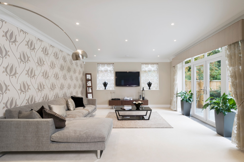 Diseño de salón contemporáneo de tamaño medio sin chimenea con paredes beige, moqueta, televisor colgado en la pared y suelo beige