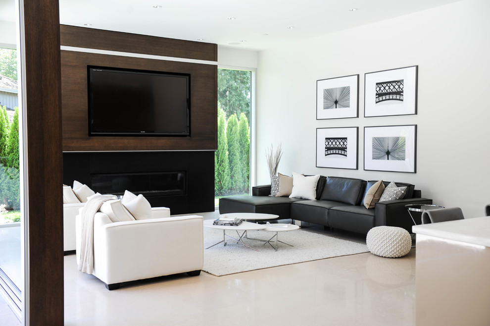 Réalisation d'un salon design avec un mur blanc, une cheminée ribbon, un téléviseur encastré et canapé noir.