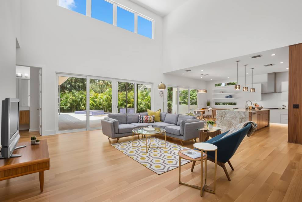 Geräumiges, Offenes Modernes Wohnzimmer mit weißer Wandfarbe, hellem Holzboden und beigem Boden in Tampa