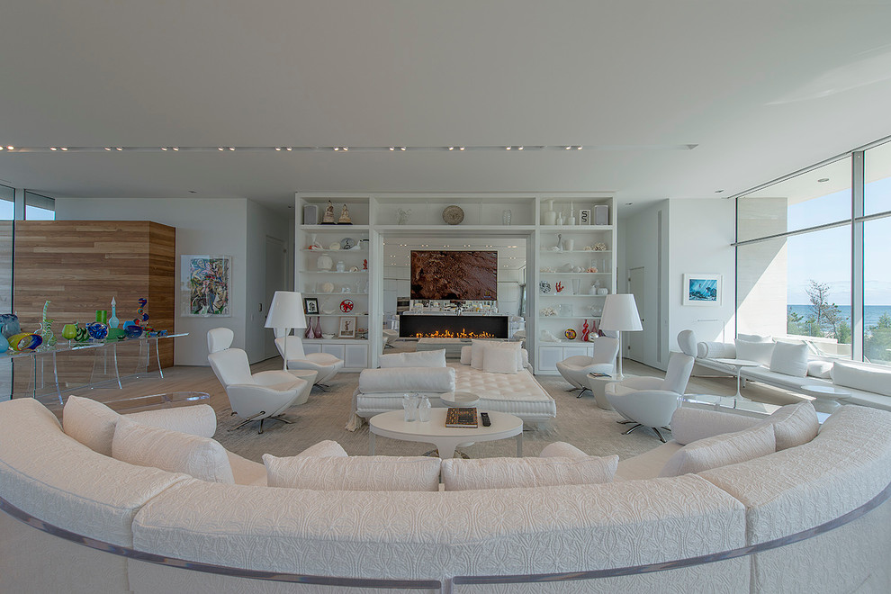 Пример оригинального дизайна: открытая гостиная комната в современном стиле с белыми стенами, горизонтальным камином и телевизором на стене