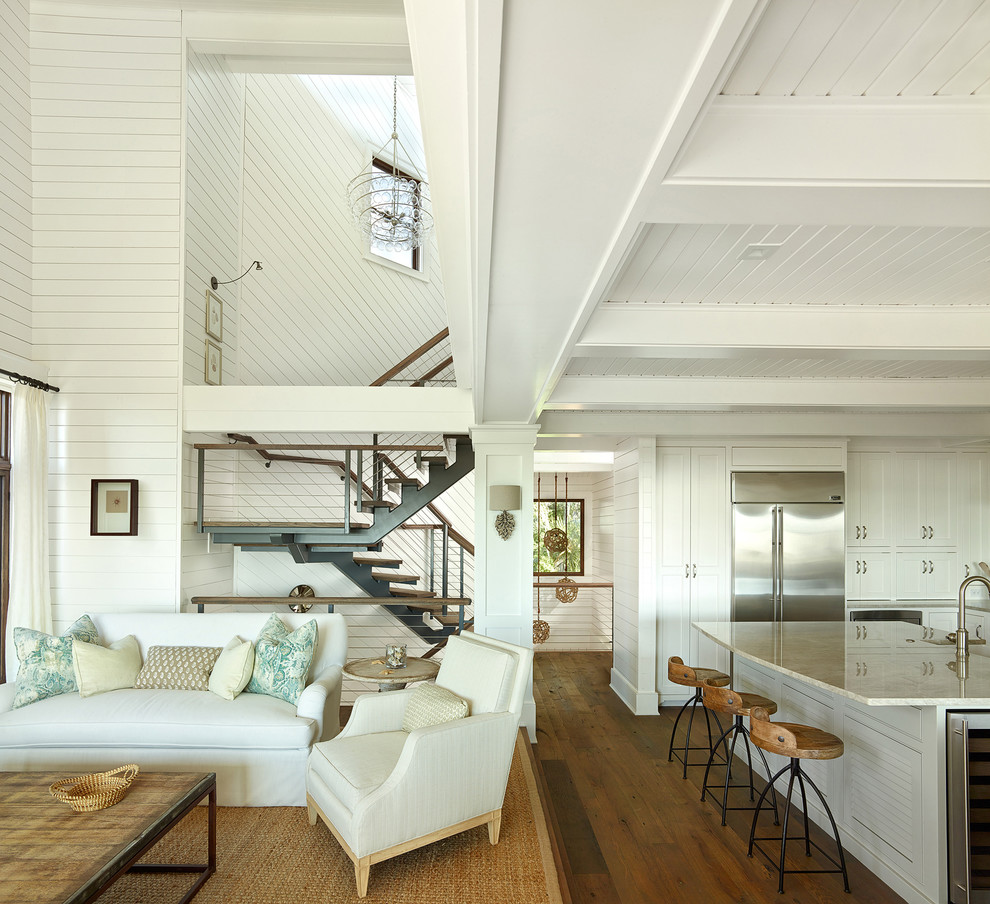 Diseño de salón abierto marinero con paredes blancas y suelo de madera en tonos medios