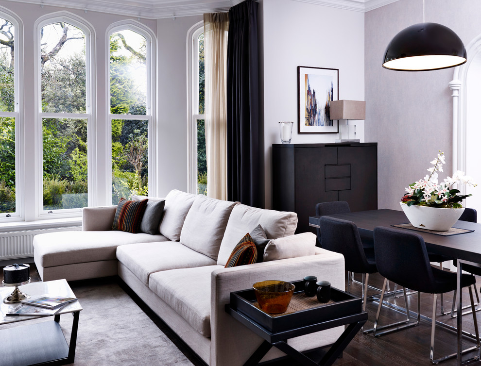 На фото: гостиная комната в стиле модернизм с серыми стенами и эркером