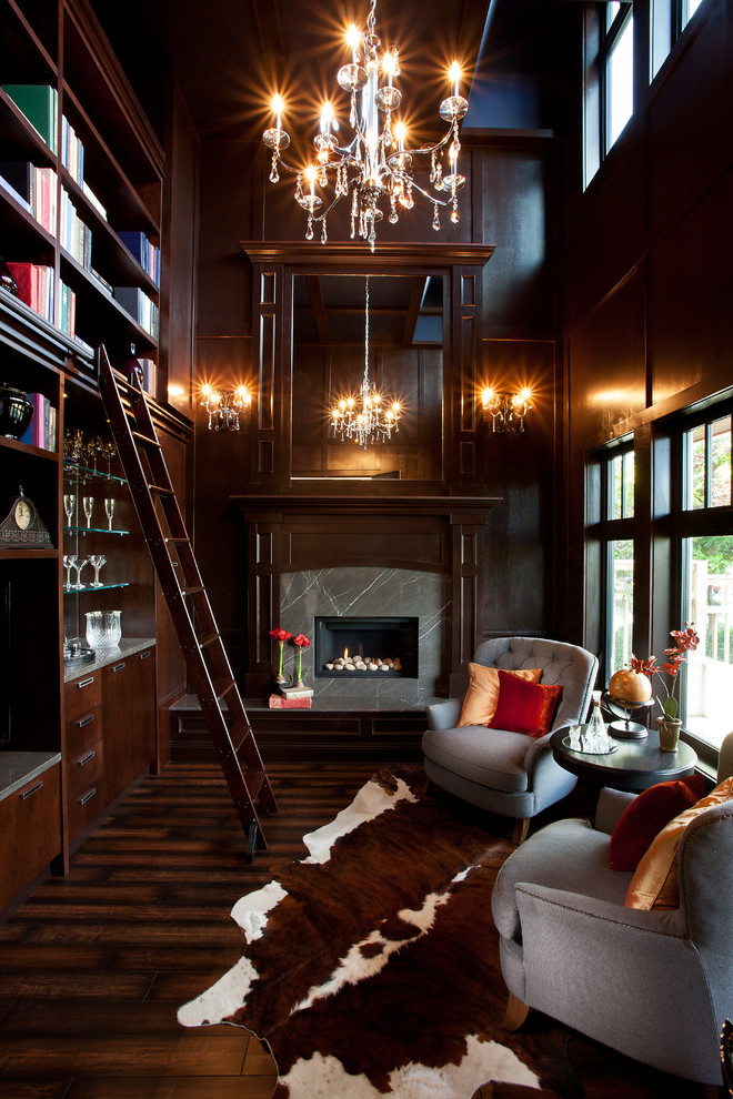 Cette photo montre un grand salon chic fermé avec une bibliothèque ou un coin lecture, une cheminée standard, parquet foncé et un manteau de cheminée en pierre.