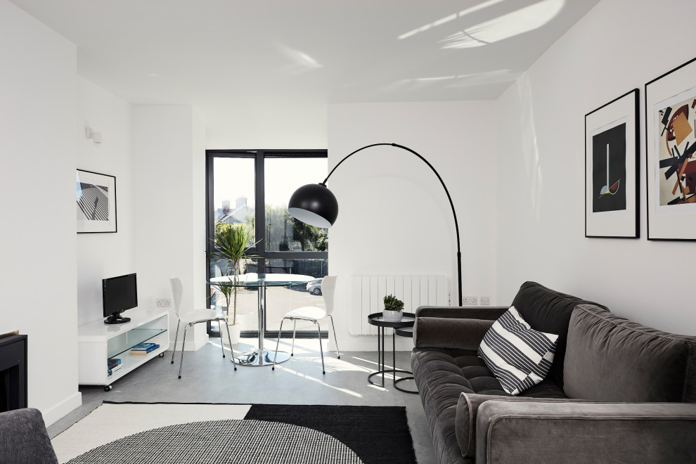 Idée de décoration pour un salon design de taille moyenne et ouvert avec un mur blanc, un sol en vinyl, une cheminée standard, un manteau de cheminée en plâtre, un téléviseur indépendant et un sol gris.