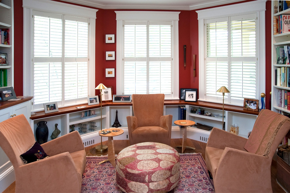 Ejemplo de biblioteca en casa tradicional de tamaño medio sin chimenea y televisor con paredes rojas y suelo de madera oscura